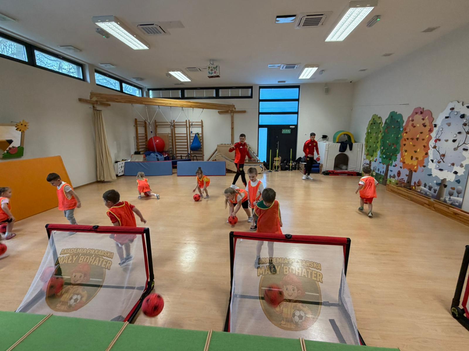 Dzieci na sali podczas zajęć z trenerem