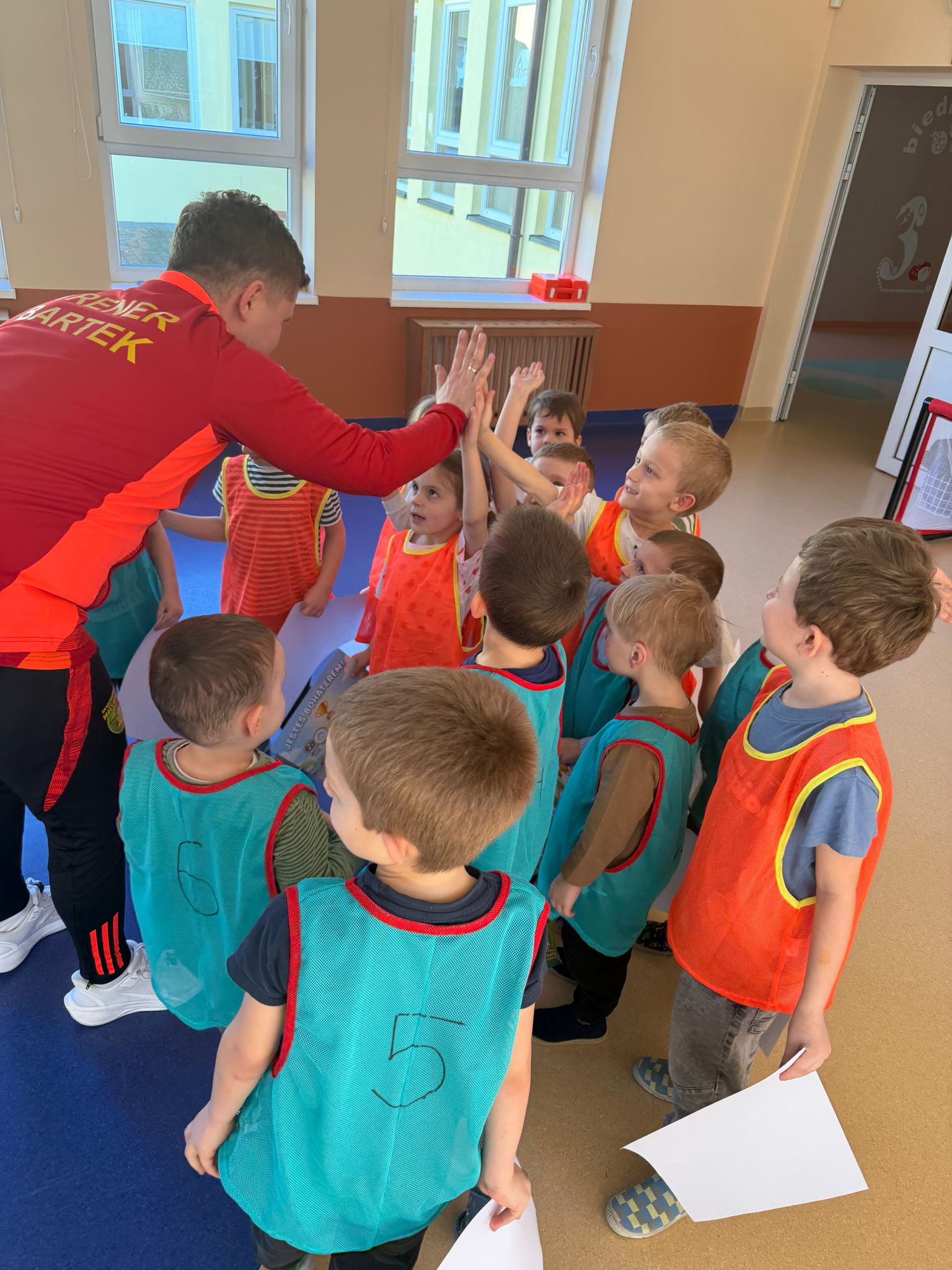 Trener przybija piątkę z dzieckiem - budowanie relacji